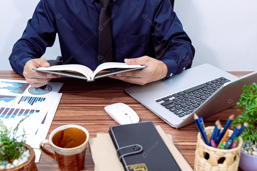 Homem de negócios que lê assentos de um livro em suas mesas