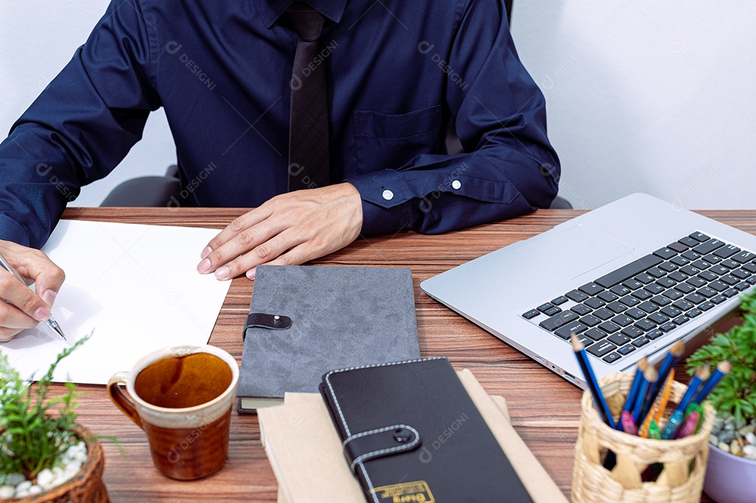 Homem de negócios escrevendo um relatório em sua mesa