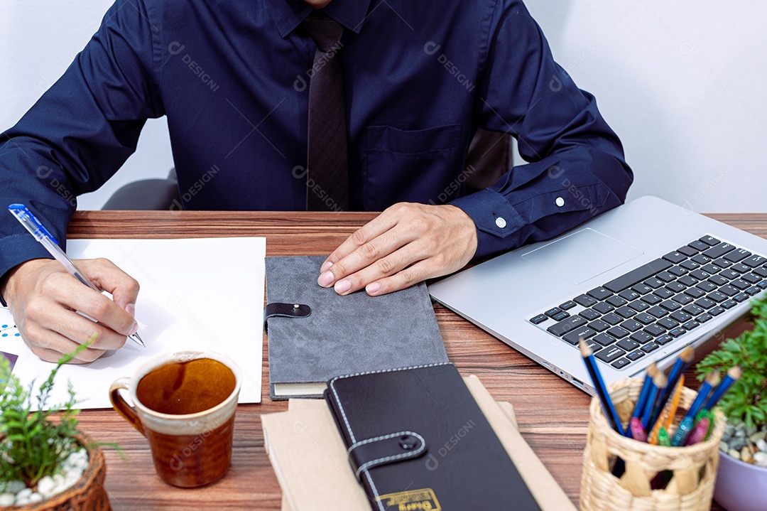 Homem de negócios escrevendo um relatório em sua mesa