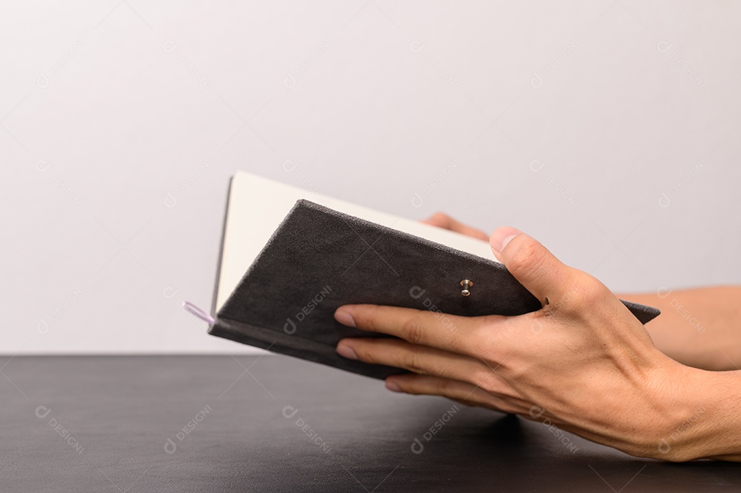 Conceito de ler o amor na mão segurando um livro na mesa