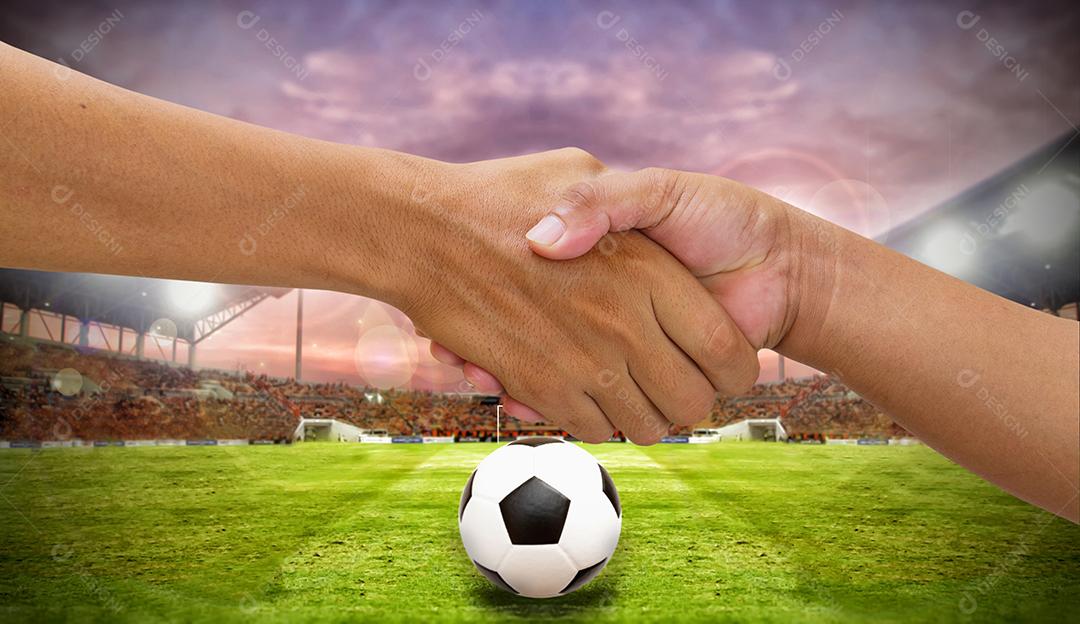 aperto de mão em um time adversário de negócios, apertando a mão no fundo do estádio de futebol