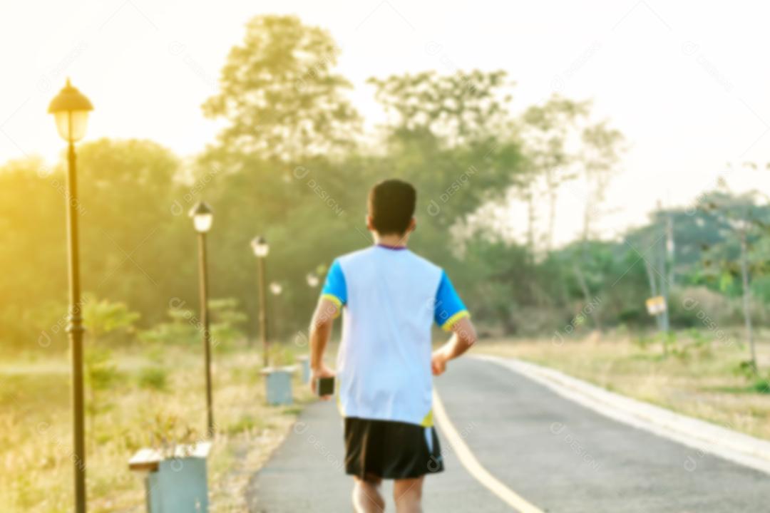 Desfocado de homem asiático Correndo e correndo durante ao ar livre na estrada.