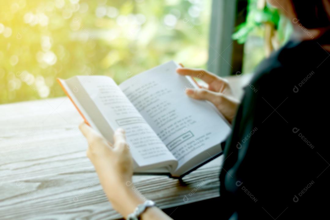 Embaçada de mulher asiática lendo um livro para relaxamento.