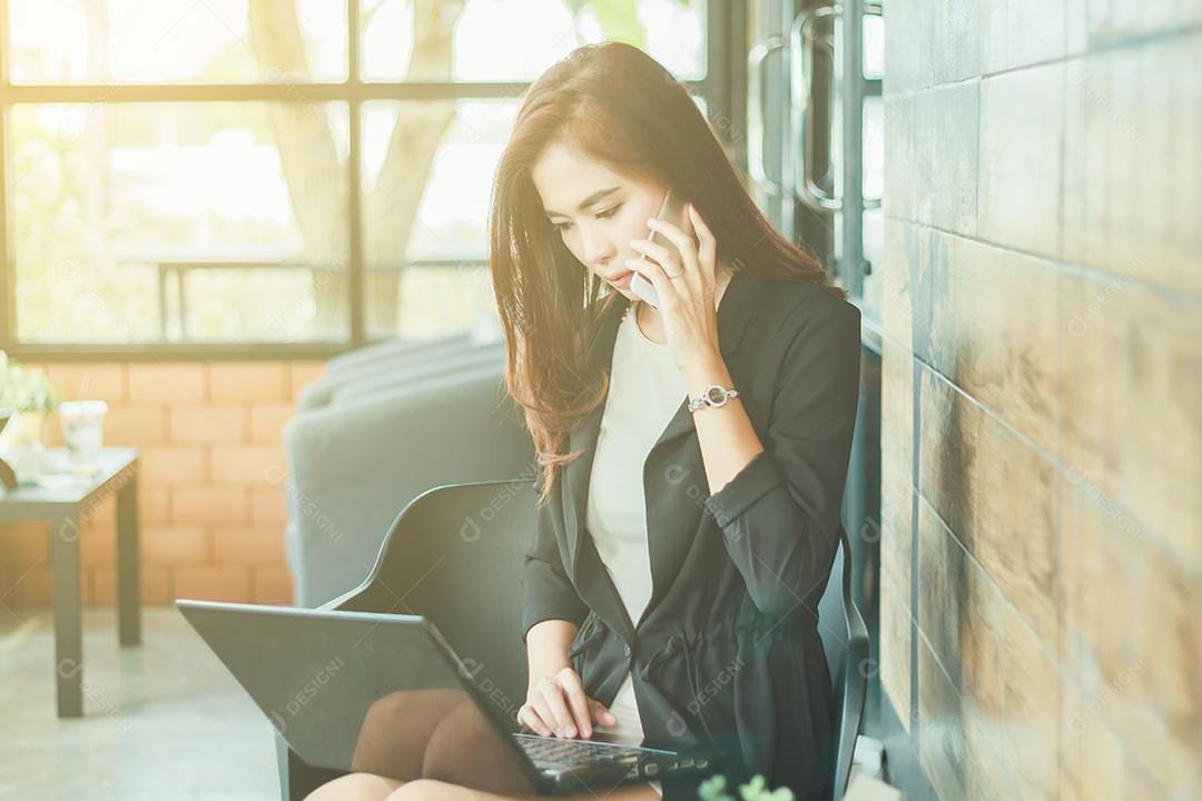 Mulher de negócios asiática usando notebook e Empresários e mulheres estão usando telefone