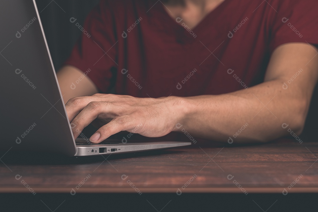 Um homem segura e usando um notebook