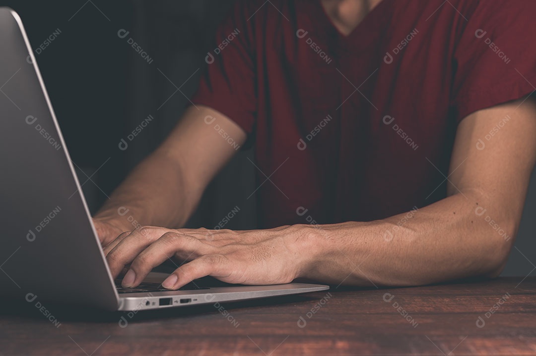 Homem segura e usa um notebook