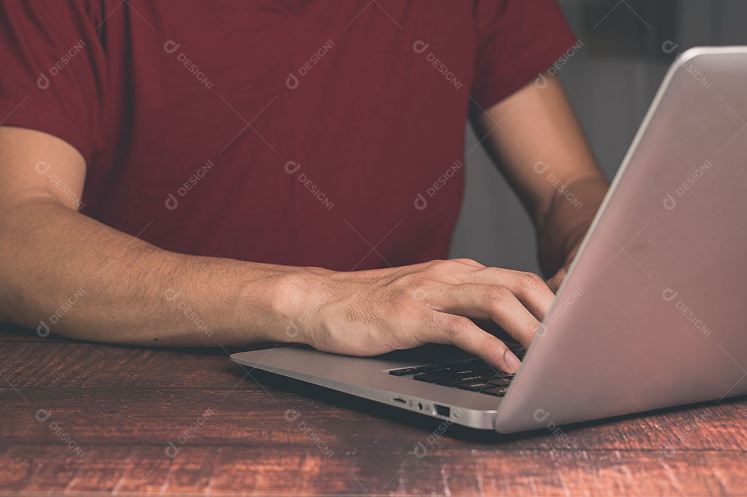 Homem segura e usa um notebook