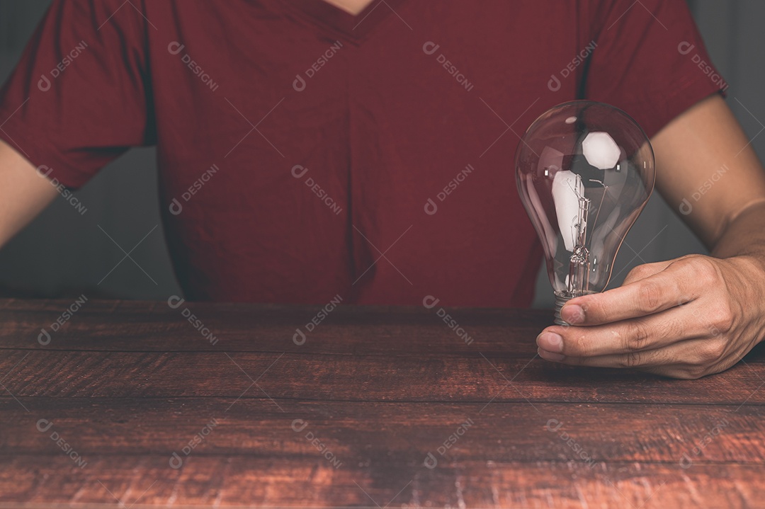 Um homem segurando uma lâmpada