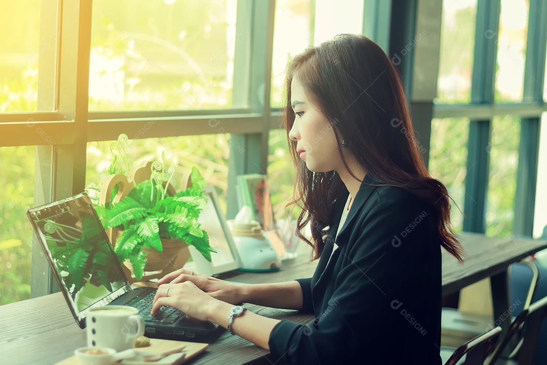 Mulheres de negócios asiáticas usando notebook e sérias sobre o trabalho