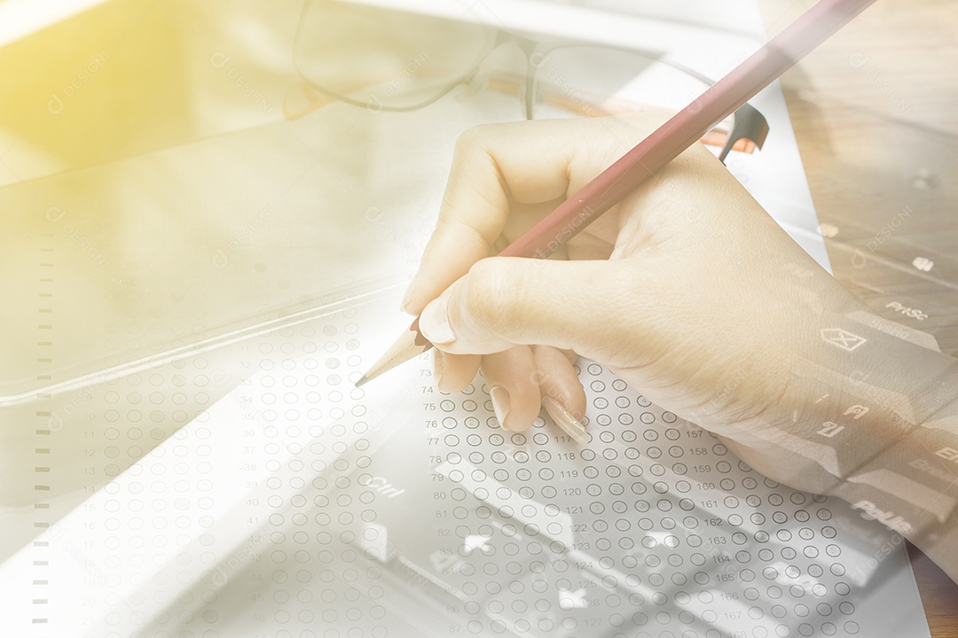 Mão de dupla exposição de mulheres segurando lápis em testes padronizados