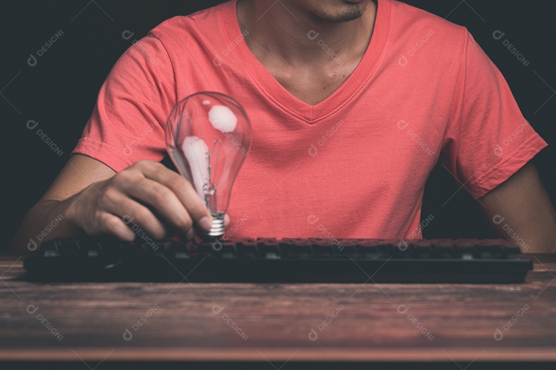 Um homem segurando uma lâmpada