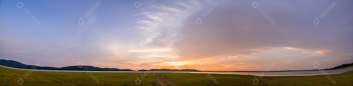 Vista do reservatório, das montanhas e do céu durante o entardecer.