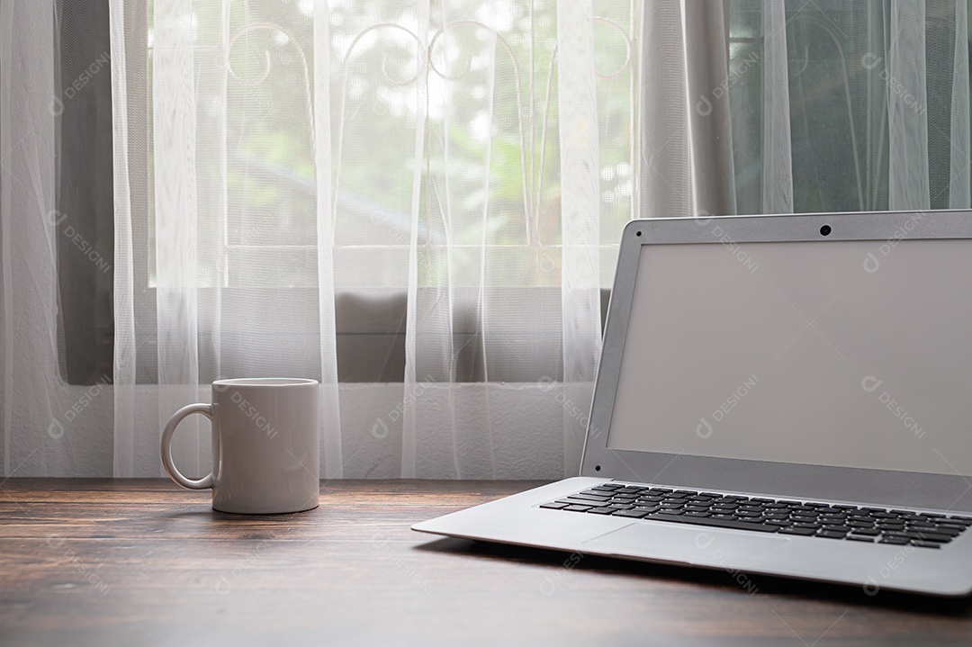 Computadores, notebooks e copos de água estão na mesa.