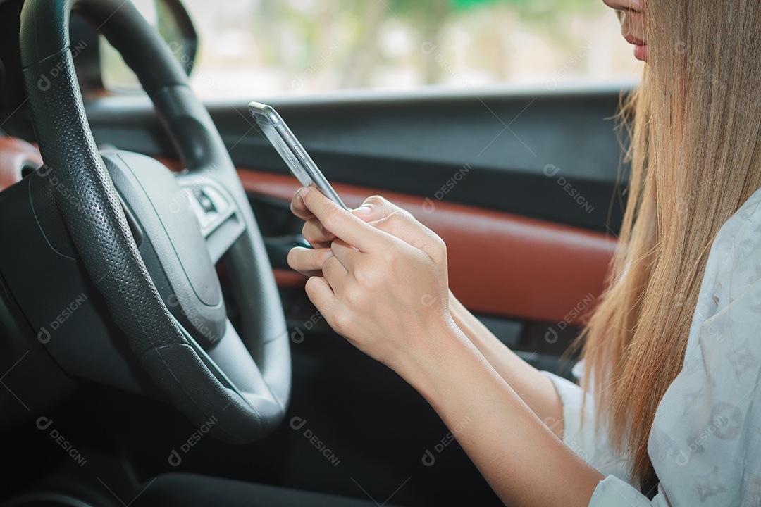 As mulheres asiáticas estão dirigindo carros e usando um smartphone na estrada.