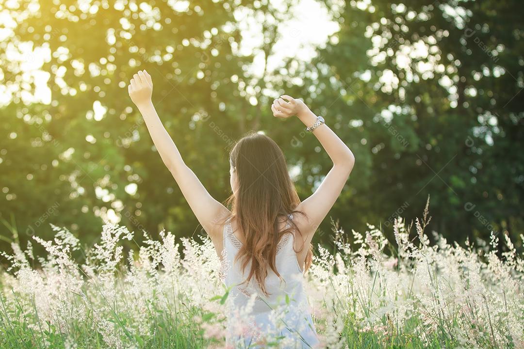 Mulher de sucesso com os braços para cima e feliz celebrando a mulher de sucesso ao pôr do sol ou nascer do sol em pé exultante com os braços levantados acima da cabeça em comemoração