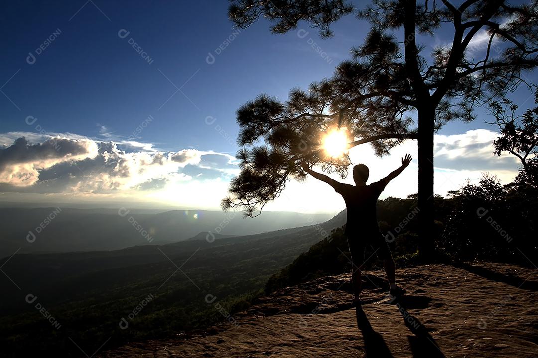 silhueta de homens mostra o braço para conquistas bem sucedidas e comemorando o sucesso no pôr do sol e a silhueta do empresário na montanha