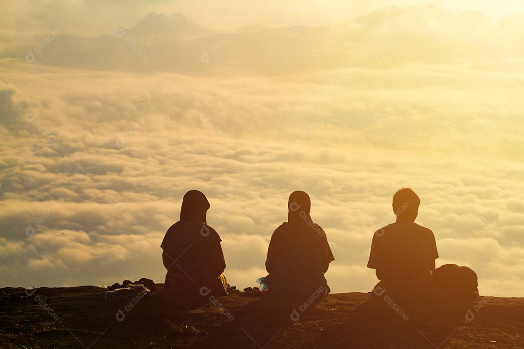 silhueta pessoas e silhueta Casal romântico e sentar e assistir o nascer do sol na montanha.