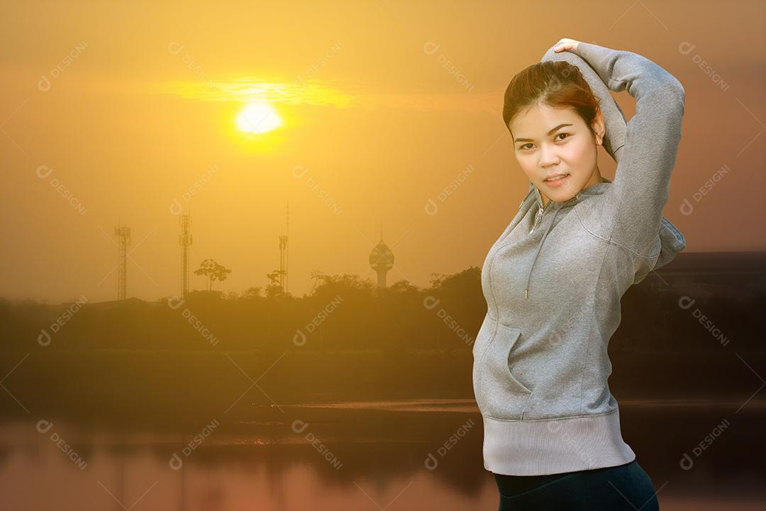 Mulher atlética asiática aquecendo e jovem atleta sentada em um exercício e alongamento em um parque antes do corredor ao ar livre, conceito de estilo de vida saudável, foco suave