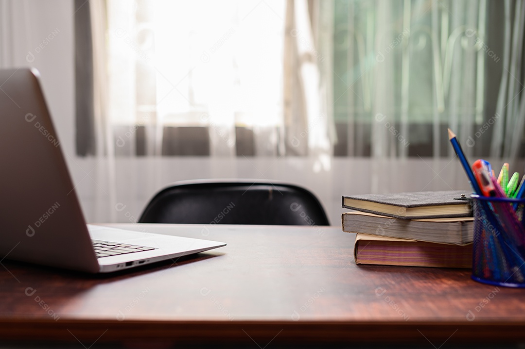 Computador portátil, livros na mesa