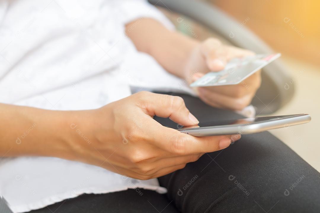 mulher asiática usando telefone e cartão de crédito compras on-line disponível