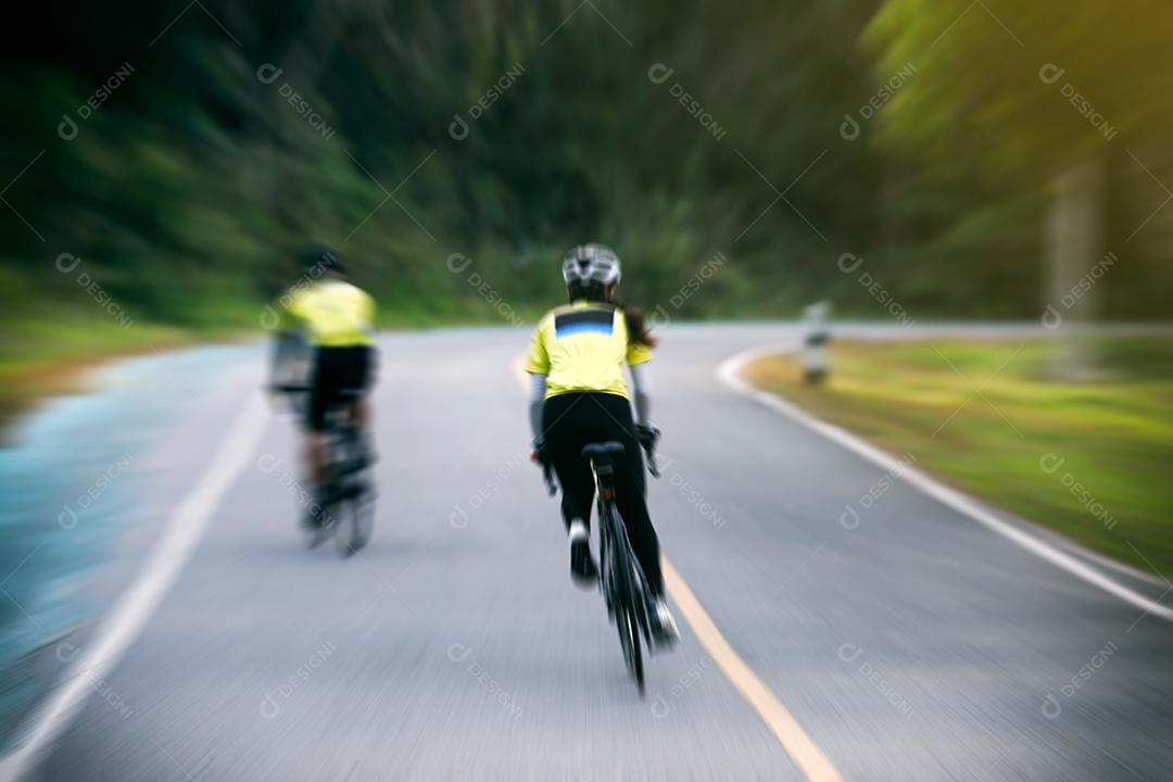 Movimento embaçado de mulheres asiáticas Ciclismo durante a corrida na estrada