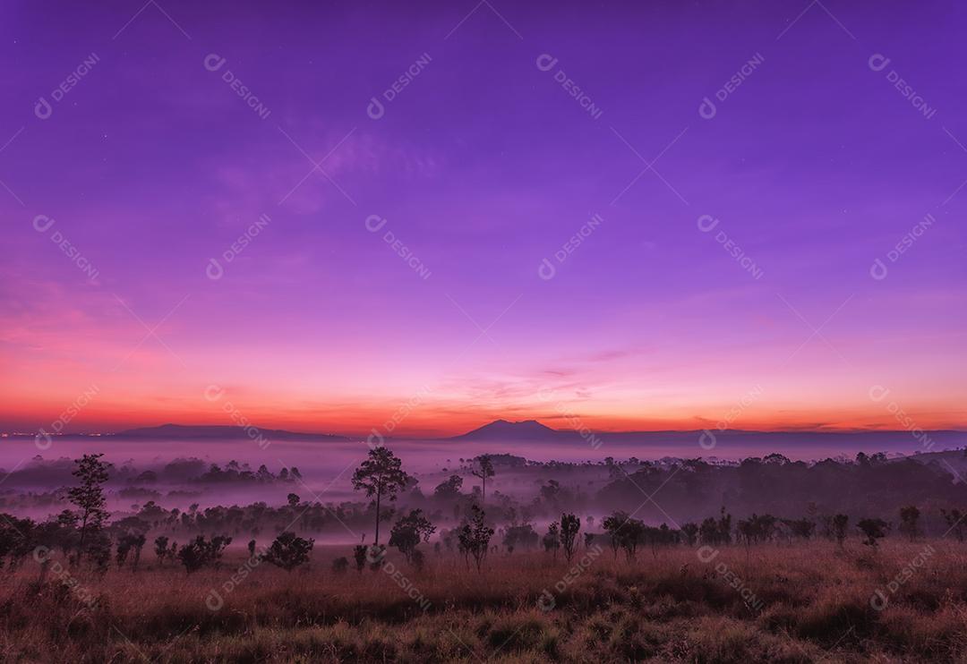Belo pôr do sol e nuvens nebulosas acima da floresta no Parque Nacional Thung Salaeng Luang, Tailândia