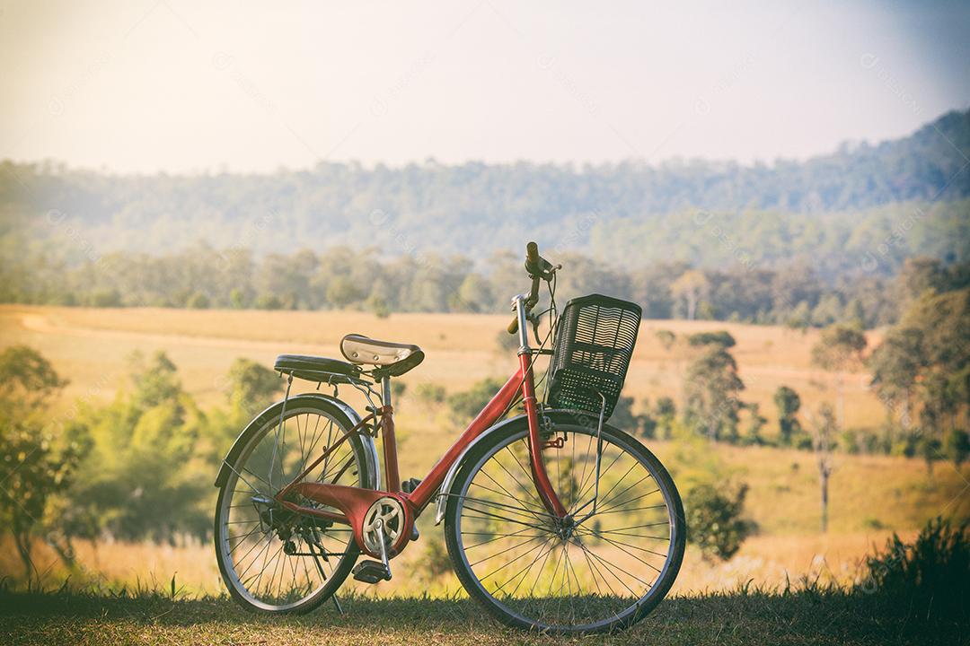 Vintage red bicycles parked on a hill at sunset.