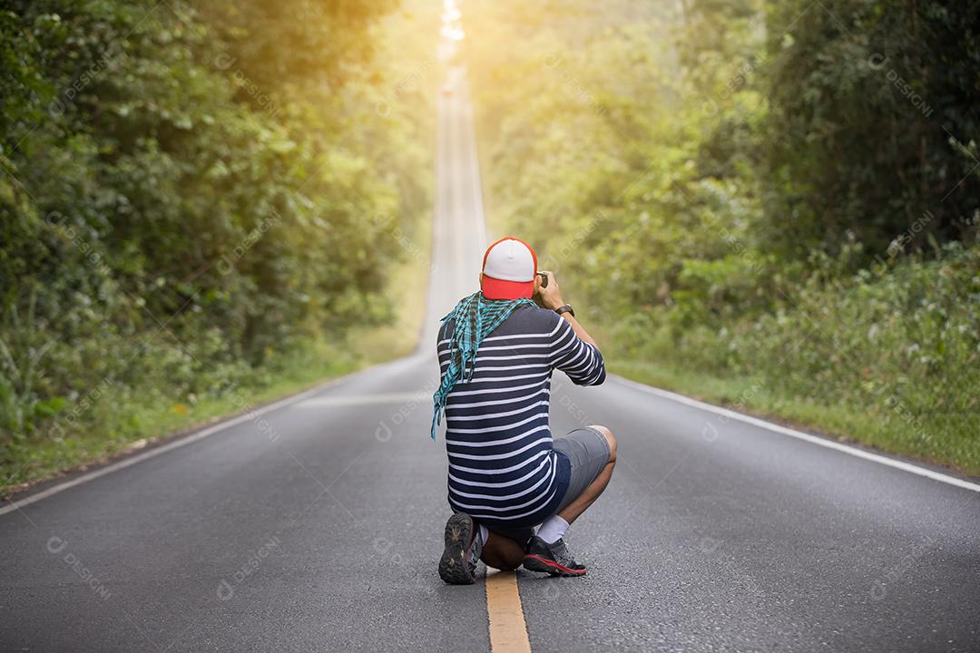 fotógrafo de homem segurando uma câmera em estado selvagem e na estrada para tirar uma foto