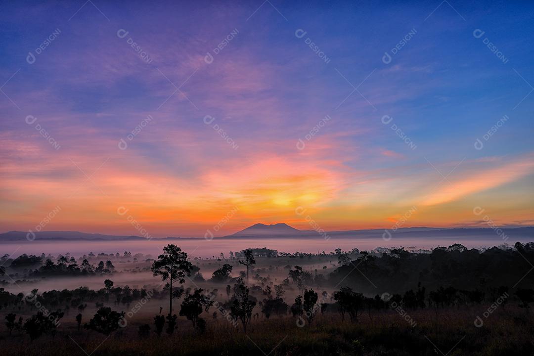 Crepúsculo do belo nascer do sol e nuvens nebulosas na floresta no Parque Nacional Thung Salaeng Luang, Tailândia