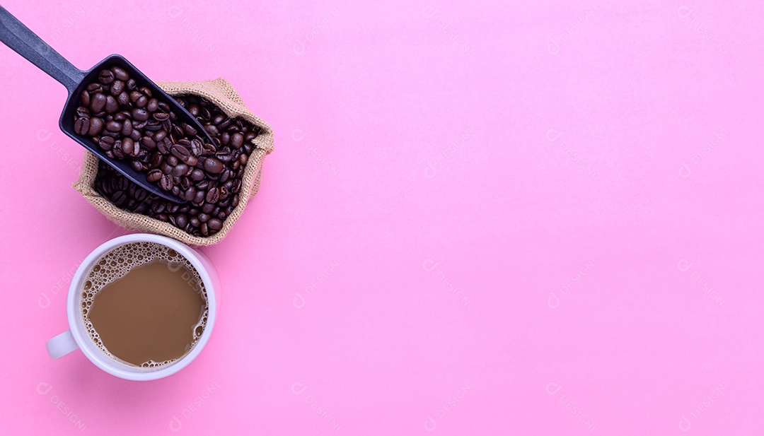 Caneca de café e grãos de café em um fundo rosa