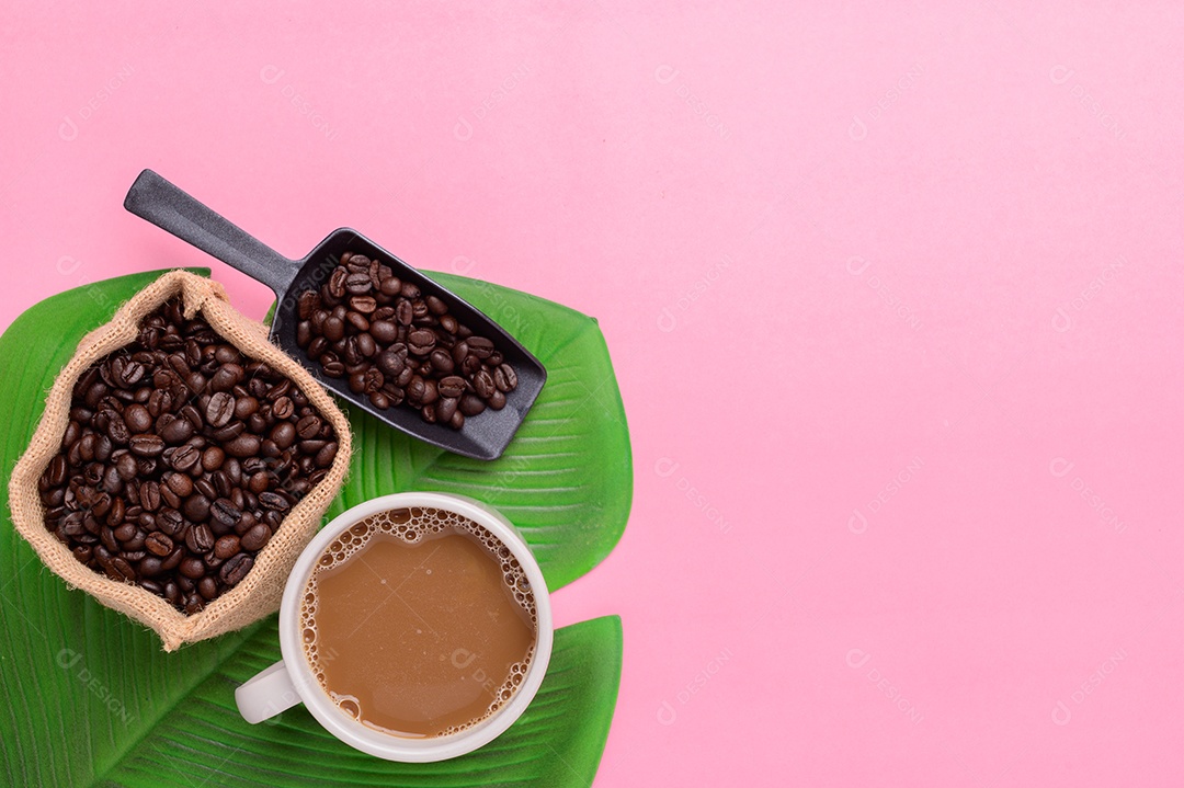 Caneca de café e grãos de café em um fundo rosa