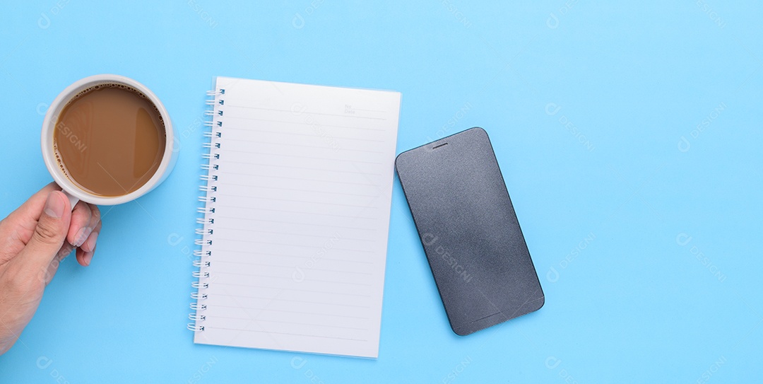 Mão segurando uma caneca de café em um fundo azul