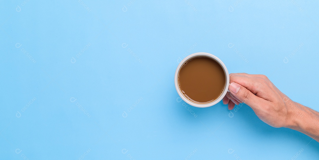 Mão segurando uma caneca de café em um fundo rosa