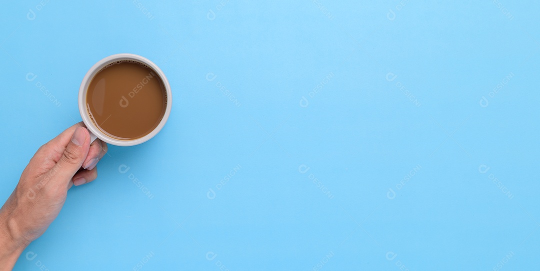 Mão segurando uma caneca de café em um fundo azul