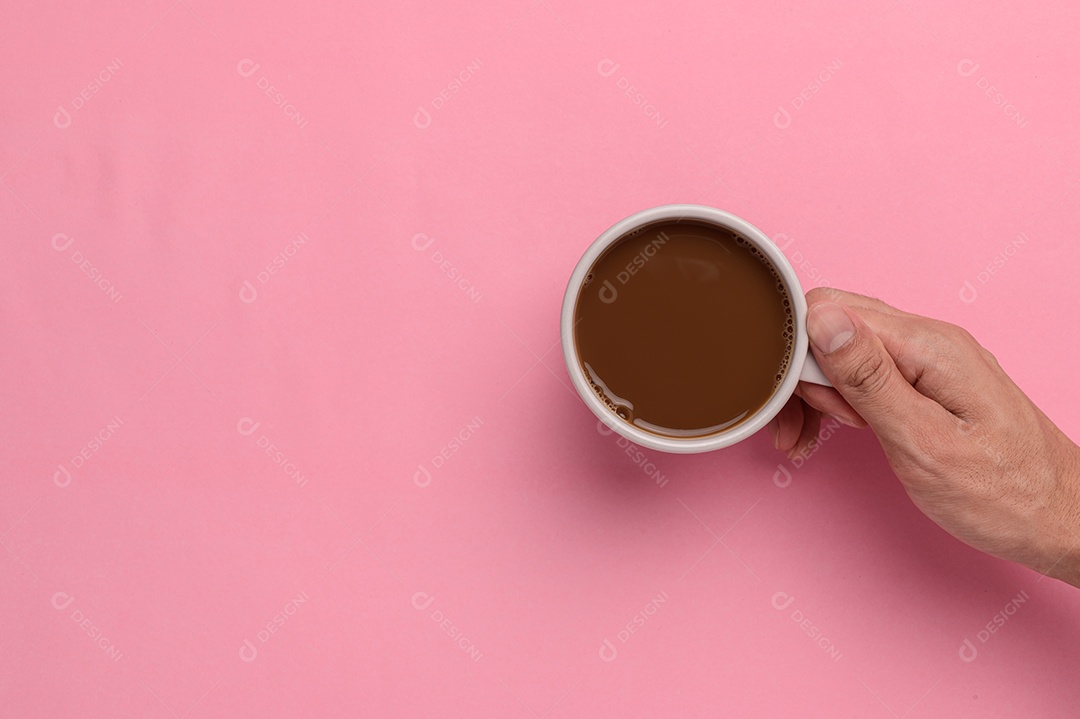 Mão segurando uma caneca de café em um fundo de madeira