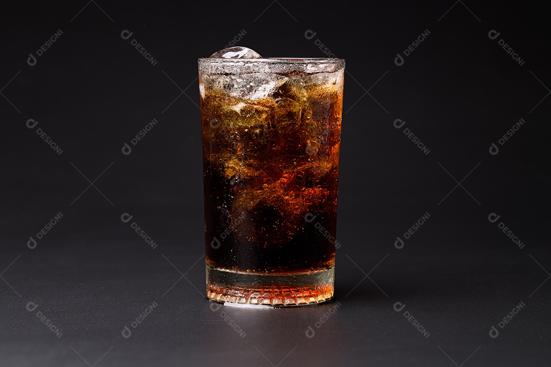 Cola em vidro com cubos de gelo transparentes isolados em fundo preto