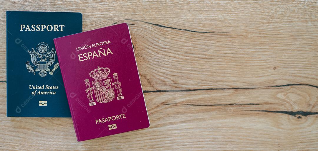 Passaportes europeus e americanos na mesa de madeira.