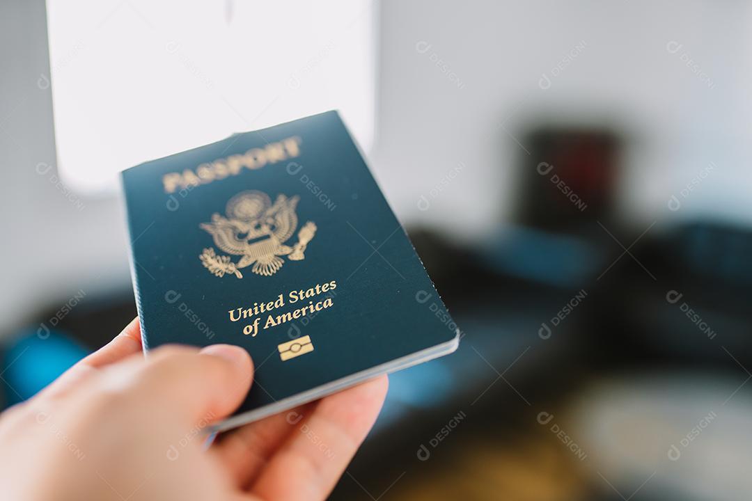 Mão segurando um passaporte americano.