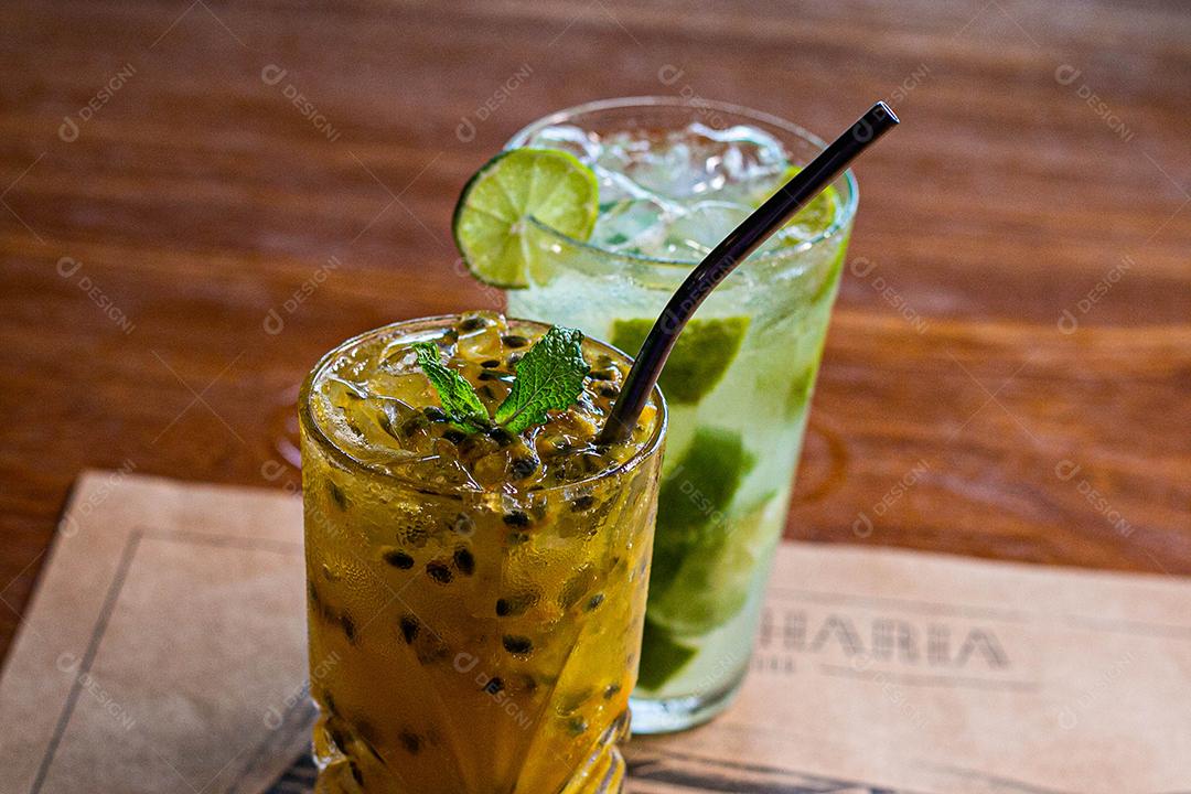 Caipirinha de maracujá ao lado de uma caipirinha de limão