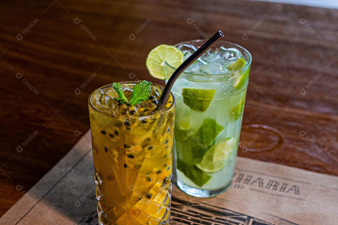 Caipirinha de maracujá ao lado de uma caipirinha de limão