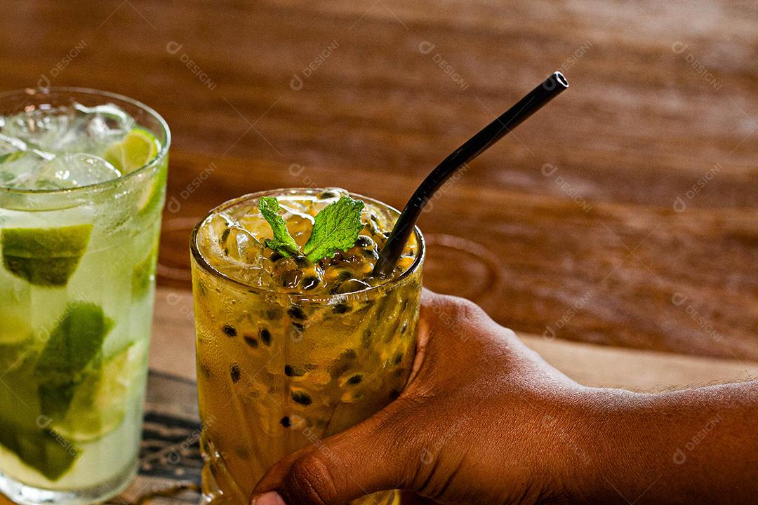 Caipirinha de maracujá ao lado de uma caipirinha de limão