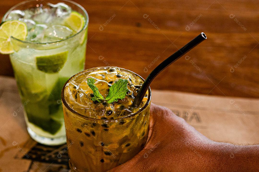 Caipirinha de maracujá ao lado de uma caipirinha de limão