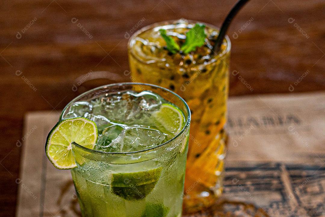 Caipirinha de maracujá ao lado de uma caipirinha de limão