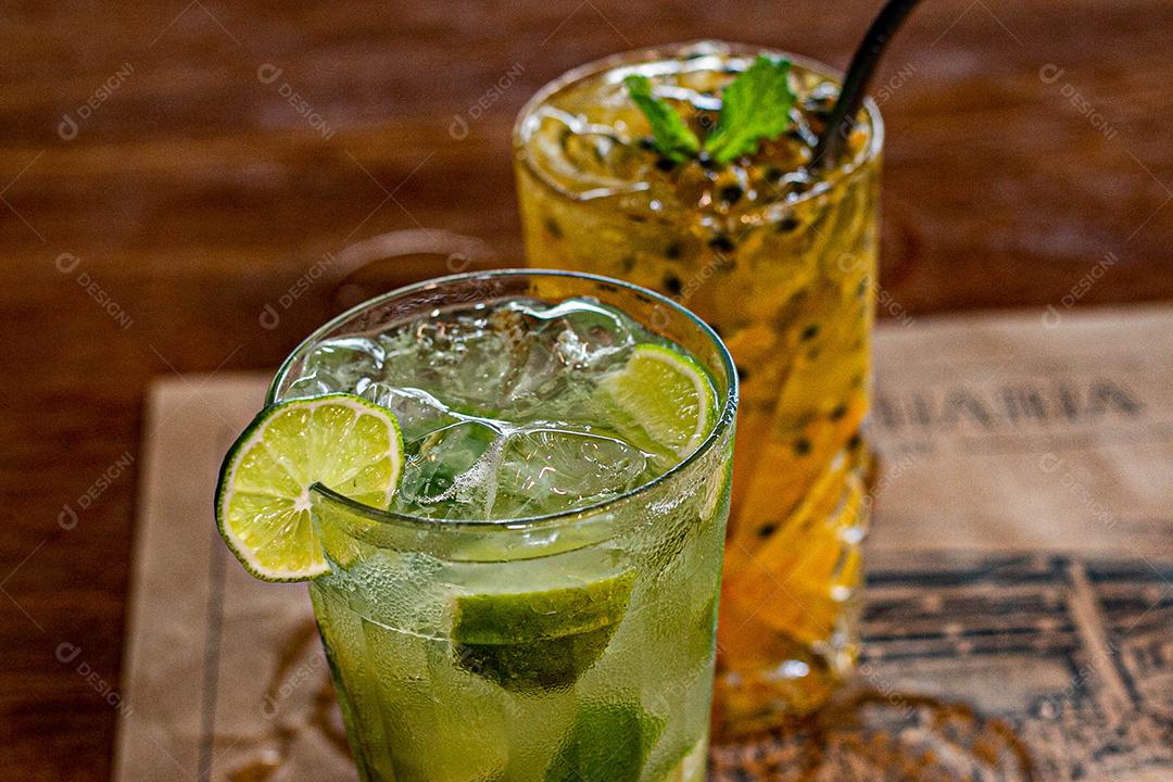 Caipirinha de maracujá ao lado de uma caipirinha de limão