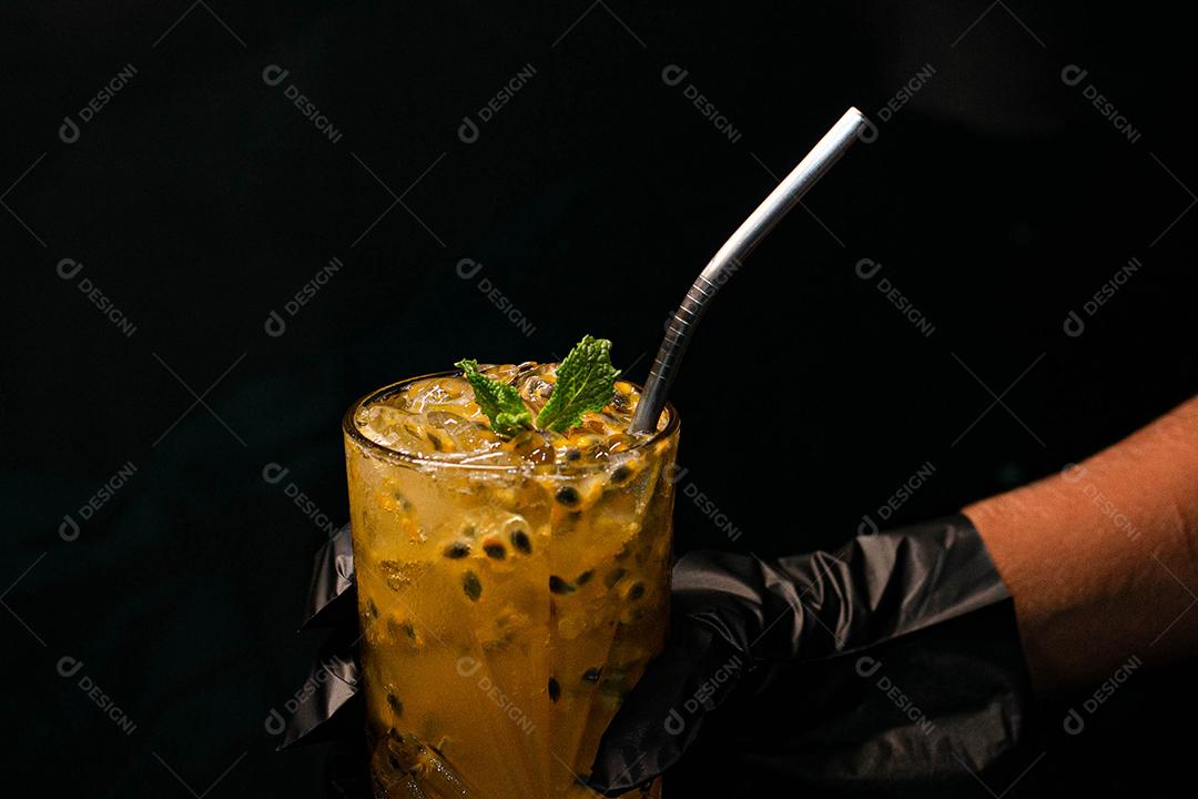 Caipirinha de maracujá com menta em fundo preto