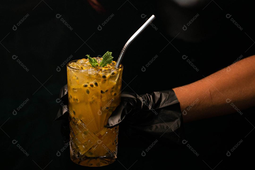 Caipirinha de maracujá com menta em fundo preto