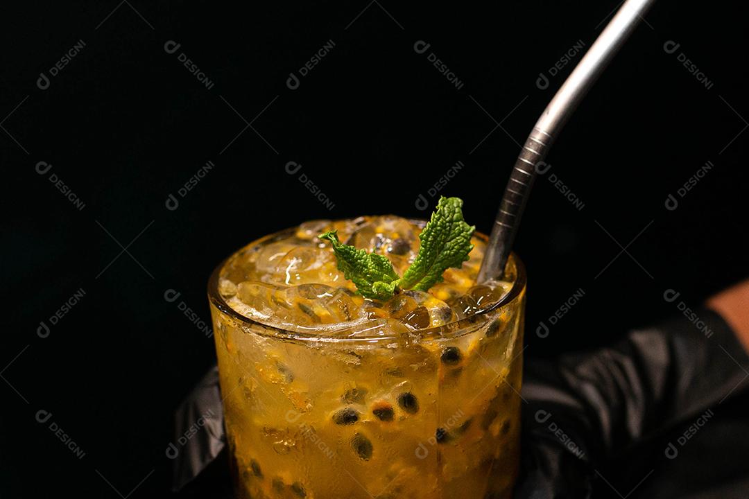 Caipirinha de maracujá com menta em fundo preto