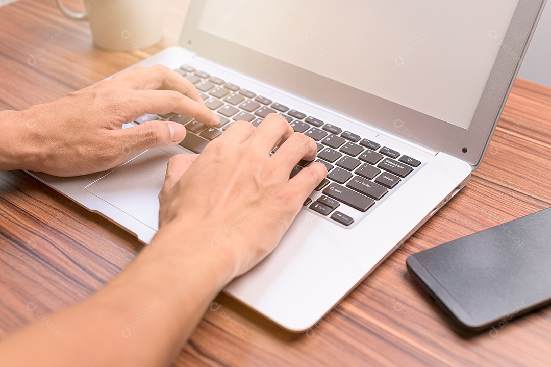 Mão usando o notebook na mesa