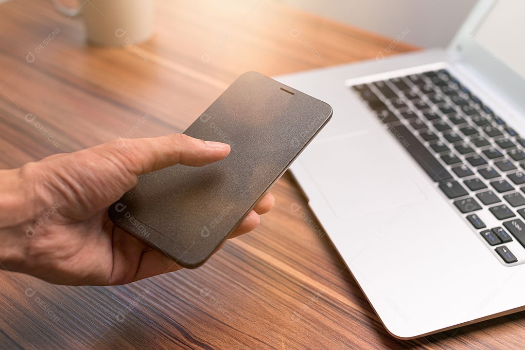 Mão usando smartphone na mesa