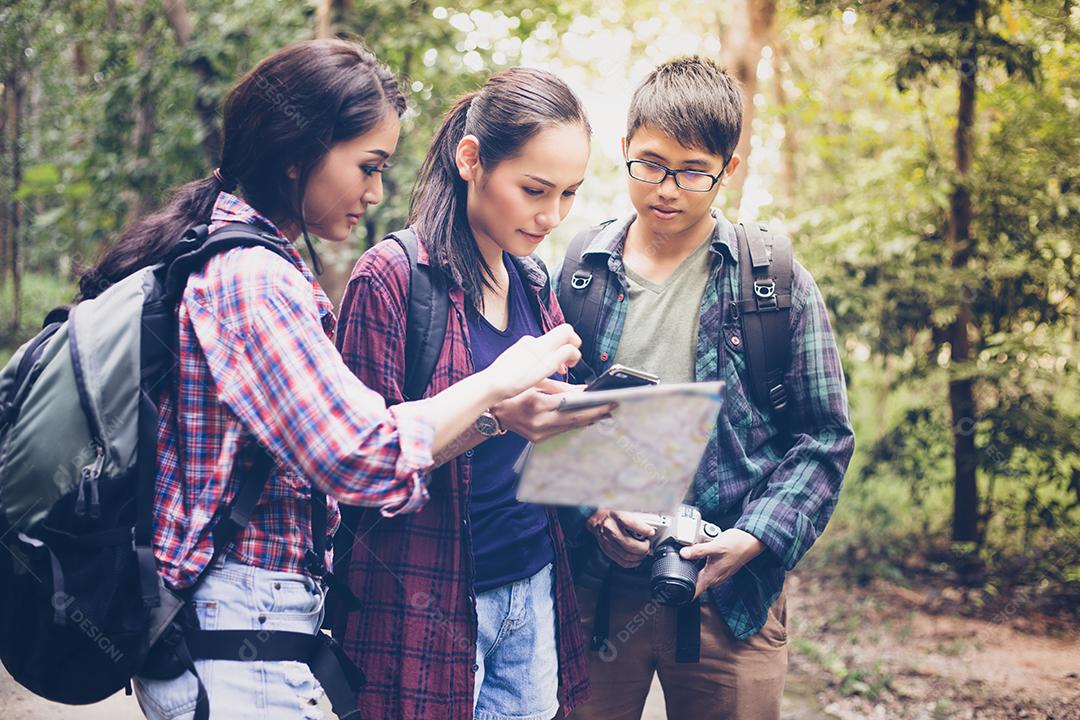 Grupo asiático de jovens Caminhando com mochilas de amigos caminhando juntos e olhando o mapa e tirando a câmera